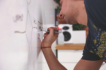 Man writing business strategy diagram on whiteboard in modern office