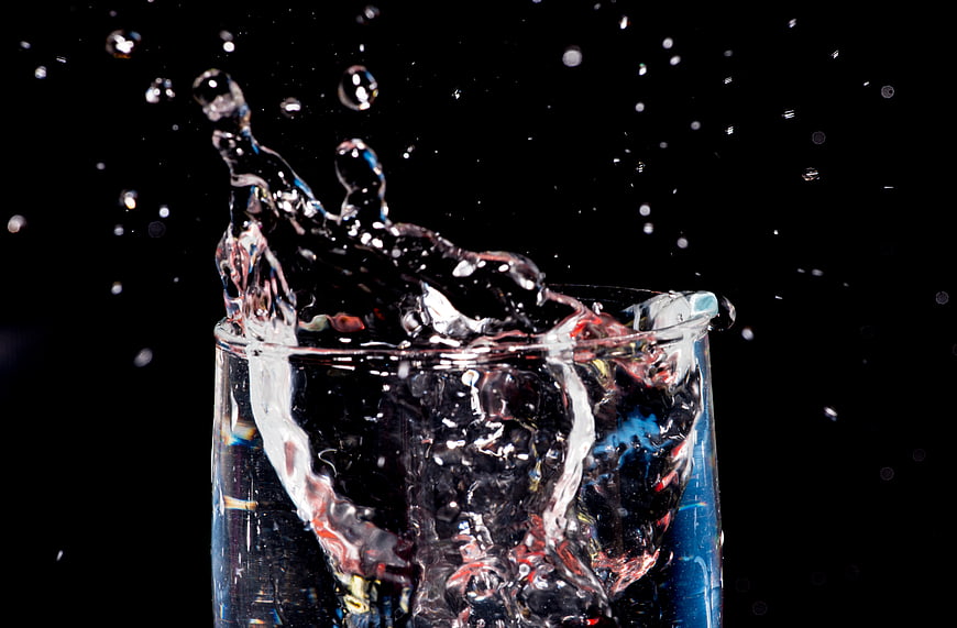 Dynamic water splash in glass on black background