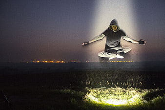Man Levitating in Meditation Pose Under Spotlight at Night