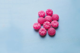 Pink fruit candies on light blue background