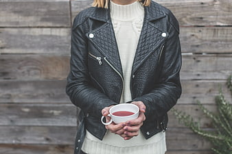 Woman in Leather Jacket Holding White Mug