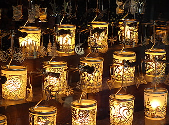 Illuminated metal tea light holders with hanging ornaments