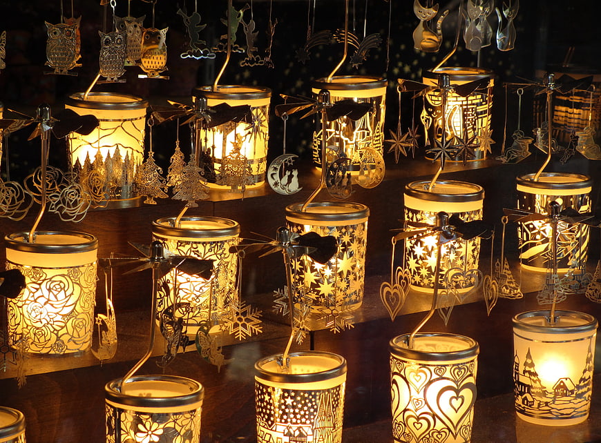 Illuminated metal tea light holders with hanging ornaments