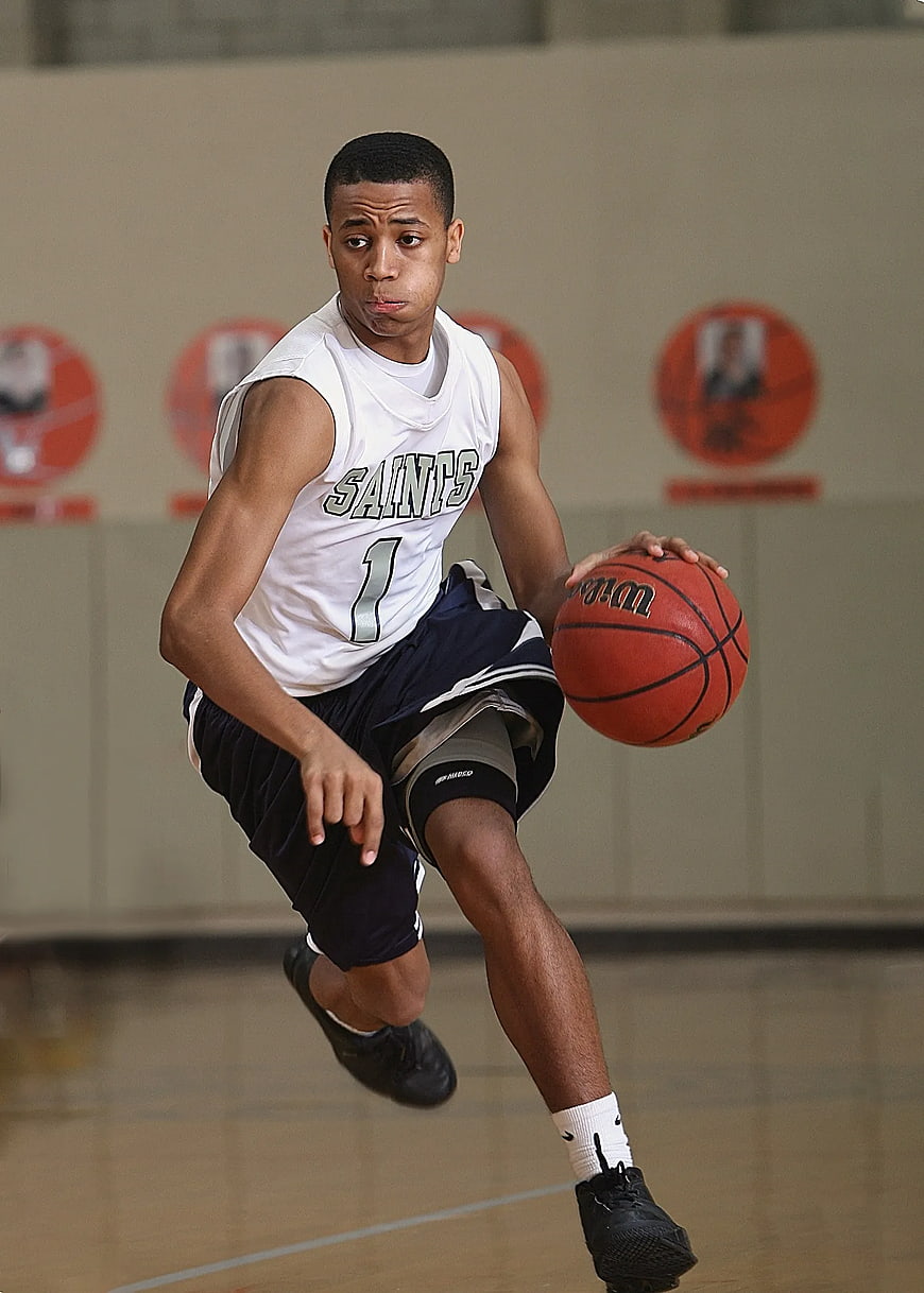 Young Male Basketball Player Dribbling in Gym