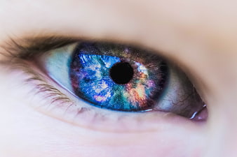Close-up of human eye with galaxy nebula contact lens