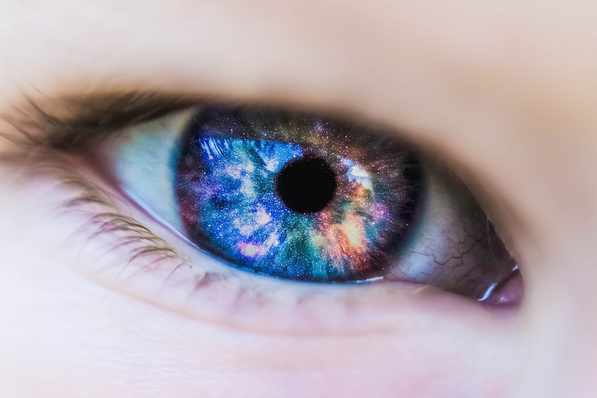 Close-up of human eye with galaxy nebula contact lens