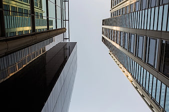 Low angle view of modern glass skyscrapers against sky