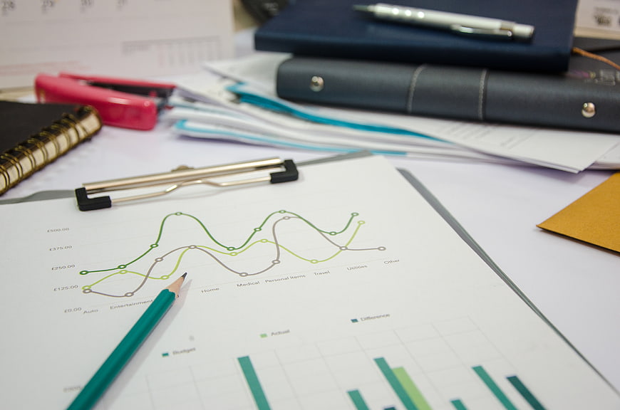Financial budget analysis charts on office desk with pencil