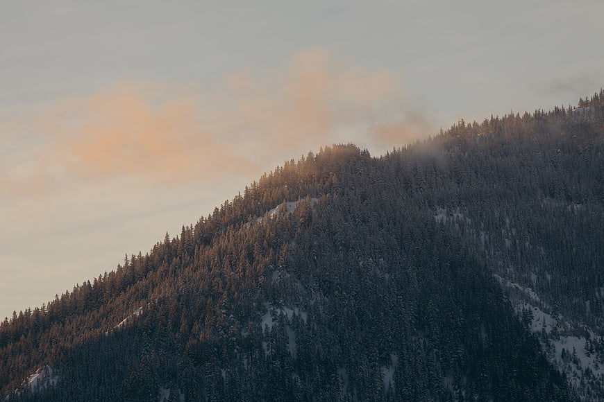 Snowy Mountain Ridge at Sunset with Soft Clouds