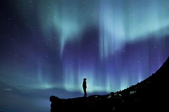 Silhouette of Person Watching Aurora Borealis at Night