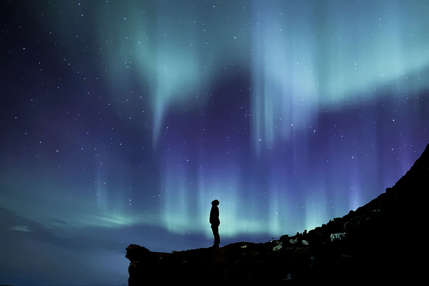 Silhouette of Person Watching Aurora Borealis at Night
