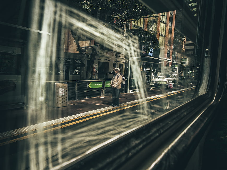 Senior man waiting at train station viewed through window