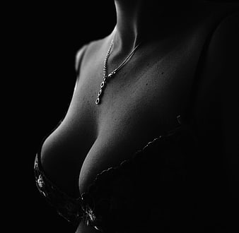 Black and white close-up of a woman's chest and necklace