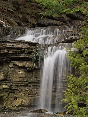 Serene waterfall cascading over layered rocks in a forest