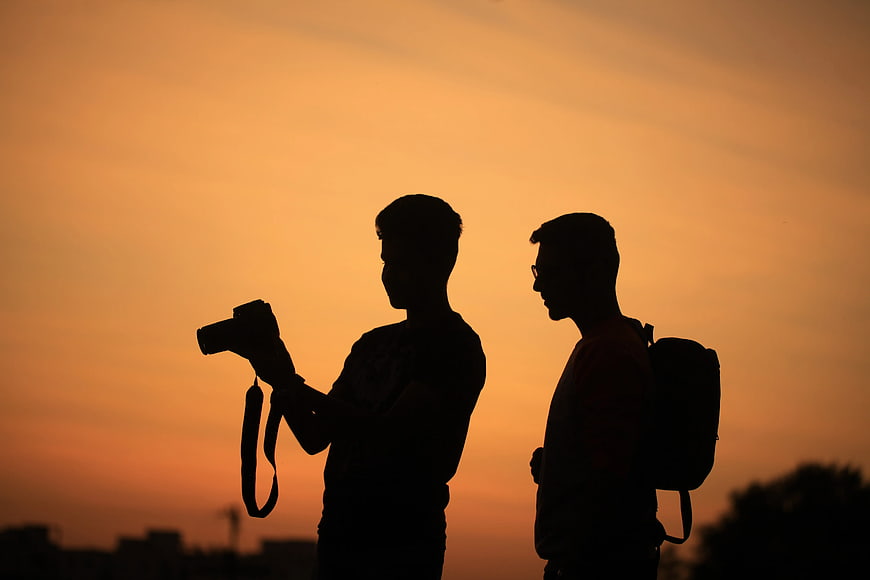 Silhouette of Two Men with Camera at Sunset
