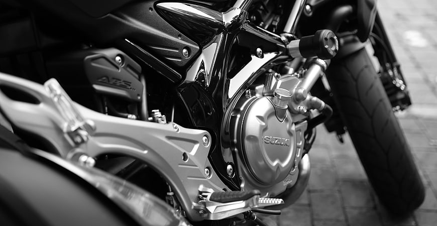 Black and white close-up of a Suzuki motorcycle engine and frame