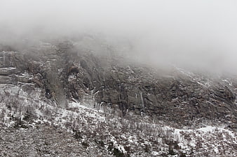 Misty Rocky Mountain Cliff in Winter Snow