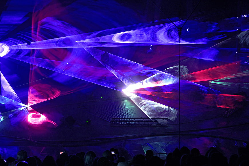 Vibrant laser light show at a nightclub with crowd