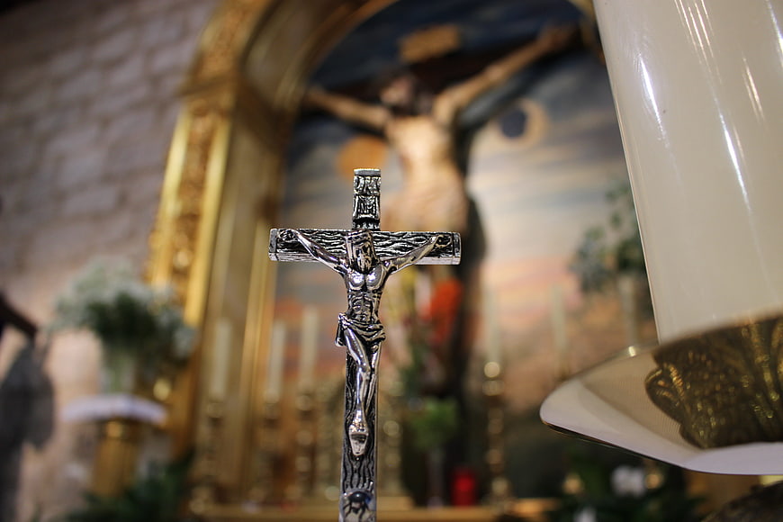 Silver Crucifix in Church with Blurred Altar Background