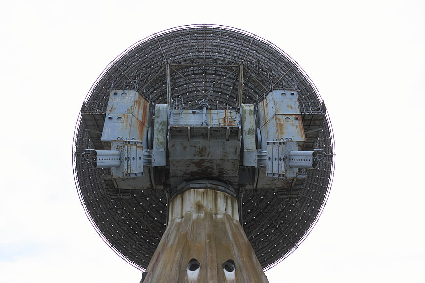 Low angle view of a large, weathered radio telescope dish antenna