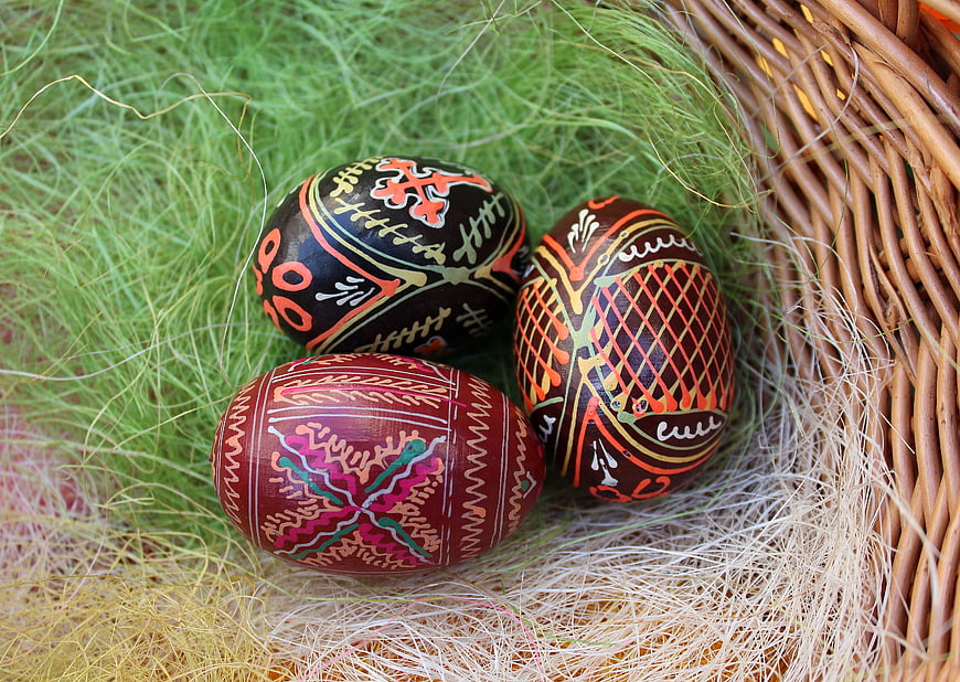 Traditional Easter Eggs in Wicker Basket with Grass