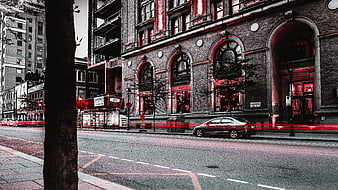 Urban street scene with red light trails and brick architecture