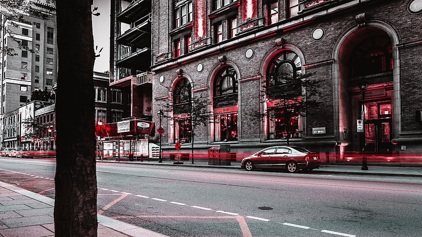 Urban street scene with red light trails and brick architecture