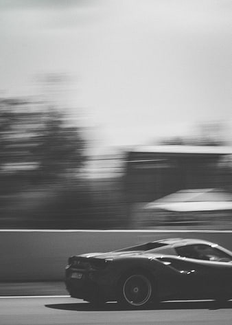 Black and white motion blur of a racing car on a track