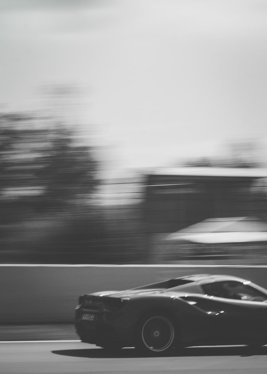 Black and white motion blur of a racing car on a track