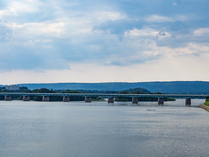 Wide River Bridge with Cloudy Sky and Distant Hills