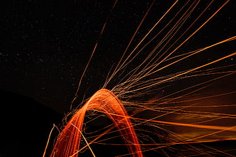 Steel wool sparks light painting against starry night sky