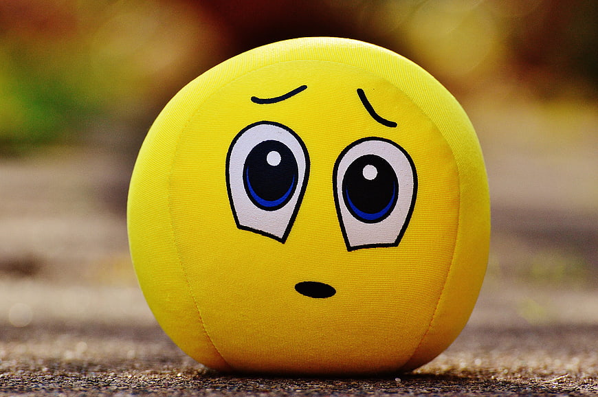 Yellow Felt Ball With Sad Cartoon Face On Ground