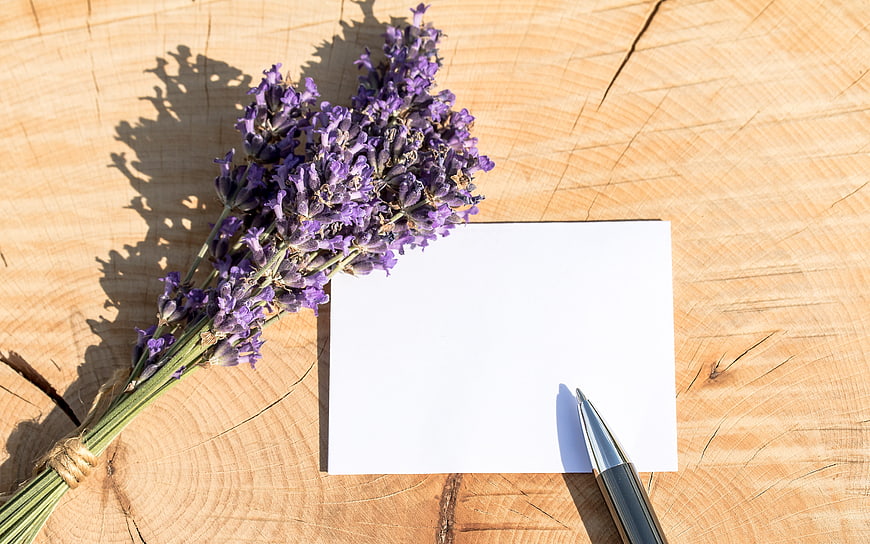 Dried lavender bouquet with blank card and pen on wood