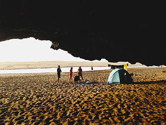 Camping under cave overhang on sandy beach