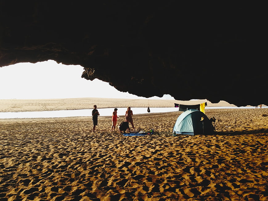 Camping under cave overhang on sandy beach