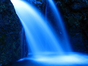 Long Exposure Blue Waterfall Flowing Over Rocks
