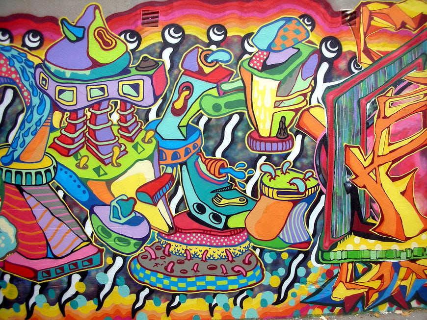 Colorful psychedelic graffiti mural with abstract characters and vibrant spray paint art