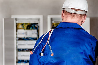 Electrician working on electrical panel with wires