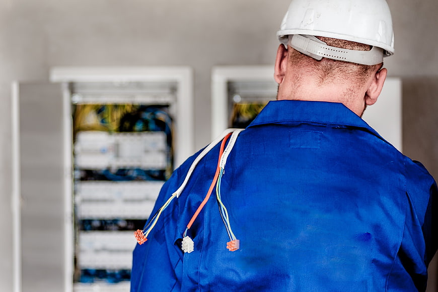 Electrician working on electrical panel with wires
