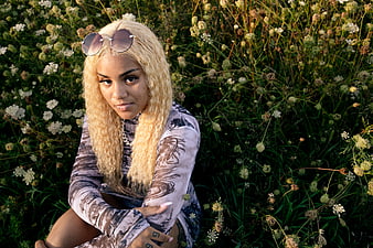 Blonde Woman with Sunglasses Sitting in Wildflower Field