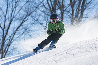 Young boy skiing downhill on snowy slope