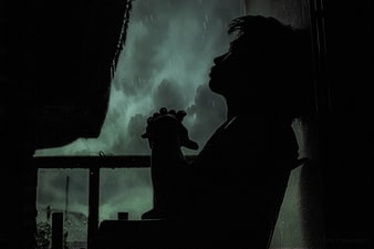 Silhouette of Boy Praying by Window in Rain