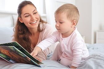 Mother and Toddler Reading Book in Bed