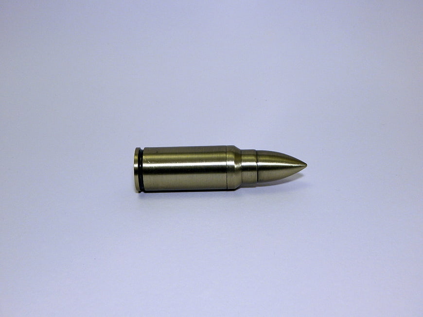 Single brass rifle cartridge on white background