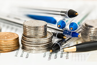 Stacks of coins and pens on financial documents