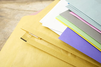 Colorful Stationery Sheets And Yellow Envelopes On Wooden Surface