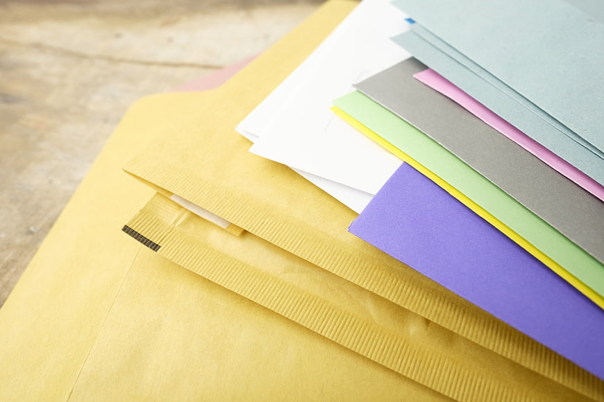 Colorful Stationery Sheets And Yellow Envelopes On Wooden Surface