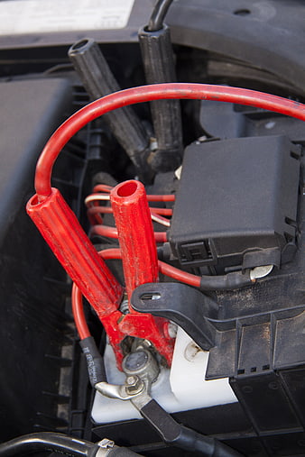 Red Jump Starter Cables Connected To Car Battery Terminal