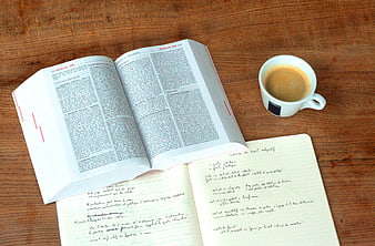 Open law book and coffee cup on wooden desk