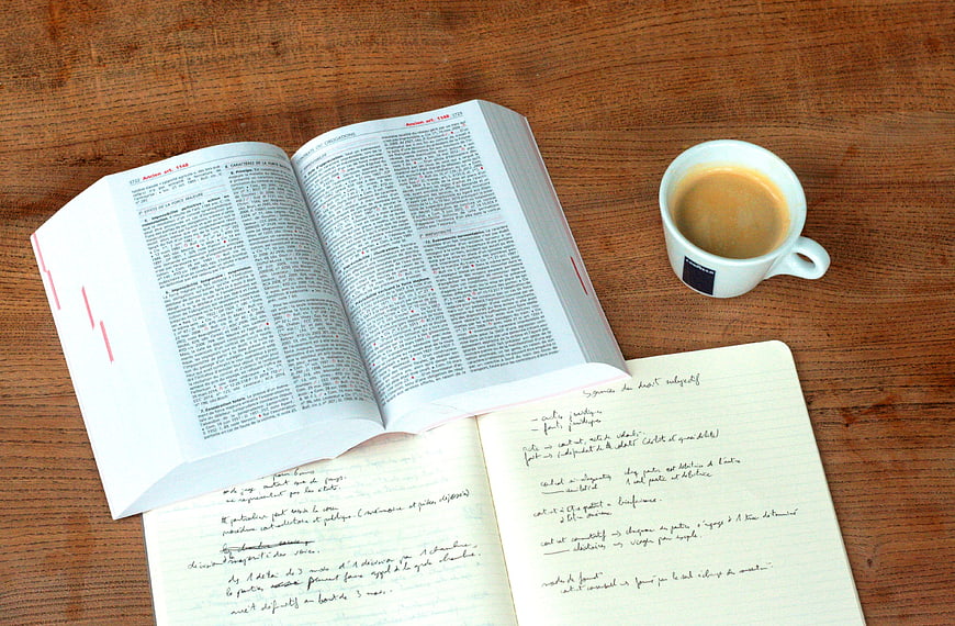 Open law book and coffee cup on wooden desk